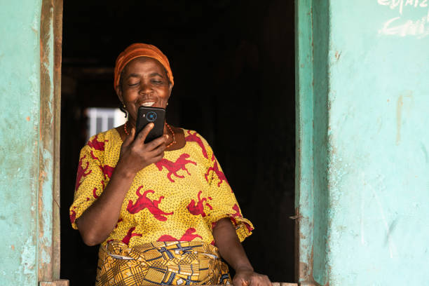 a smiling elderly african woman using her mobile phone